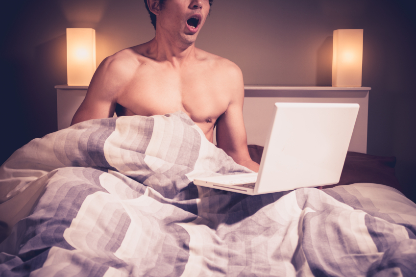Man in bed with laptop masturbating