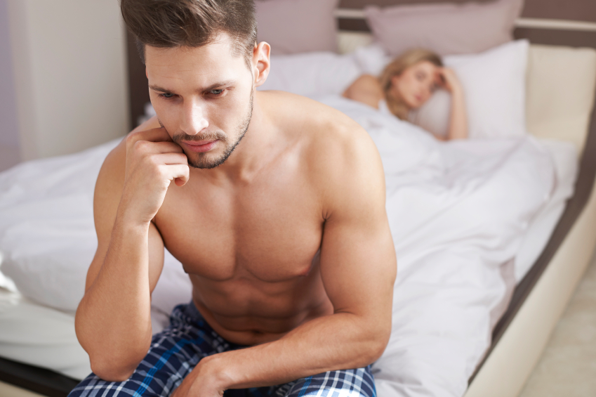 man on side of bed looking stressed