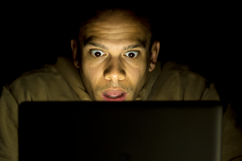 Man looks shocked at a laptop